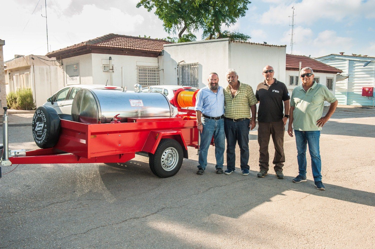 A group of men standing in front of a red trailer