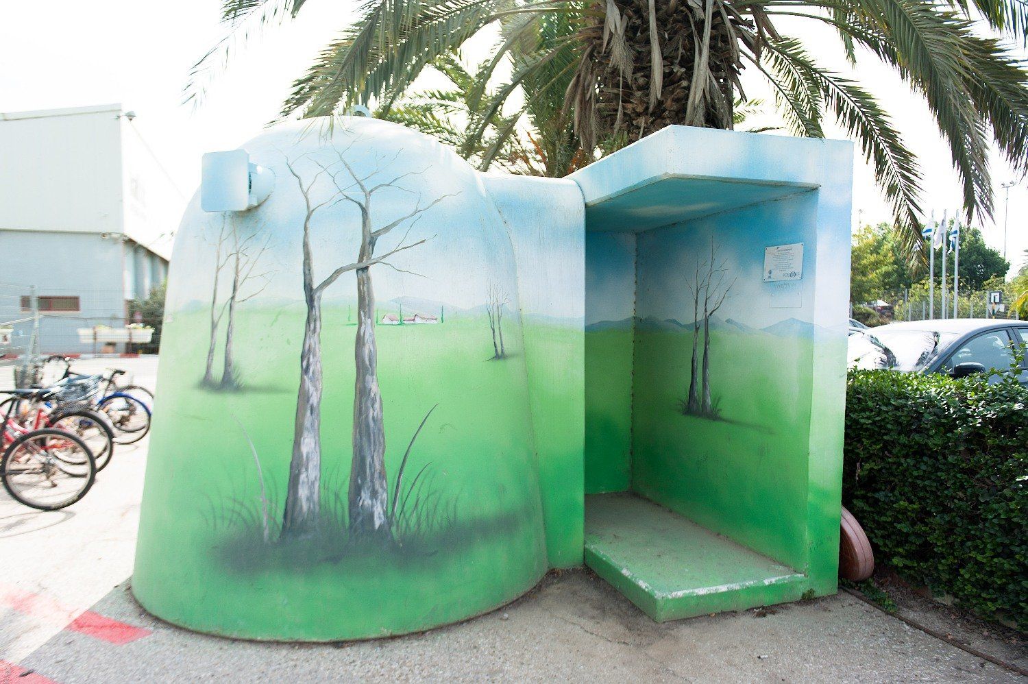 A green and blue Shelter with trees painted on it