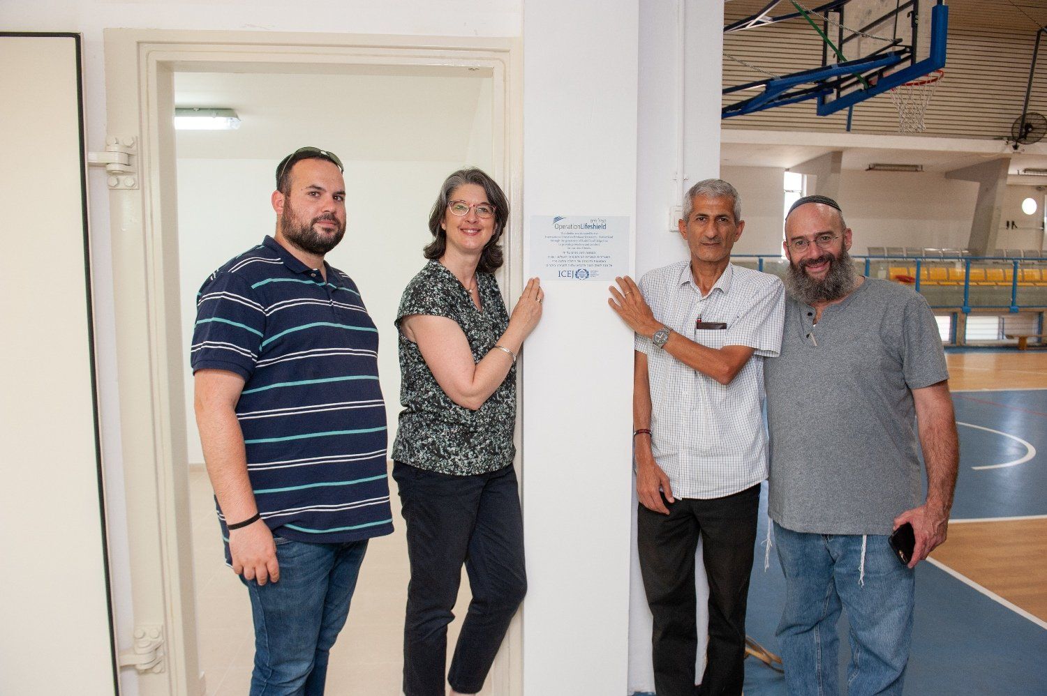 A group of people are standing next to each other in a room.