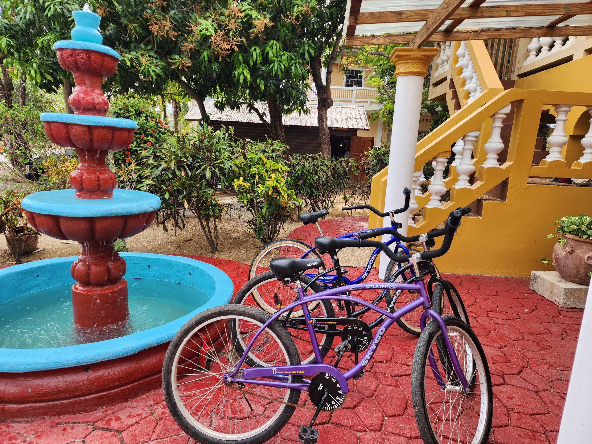 Three bicycles are parked in front of a fountain.