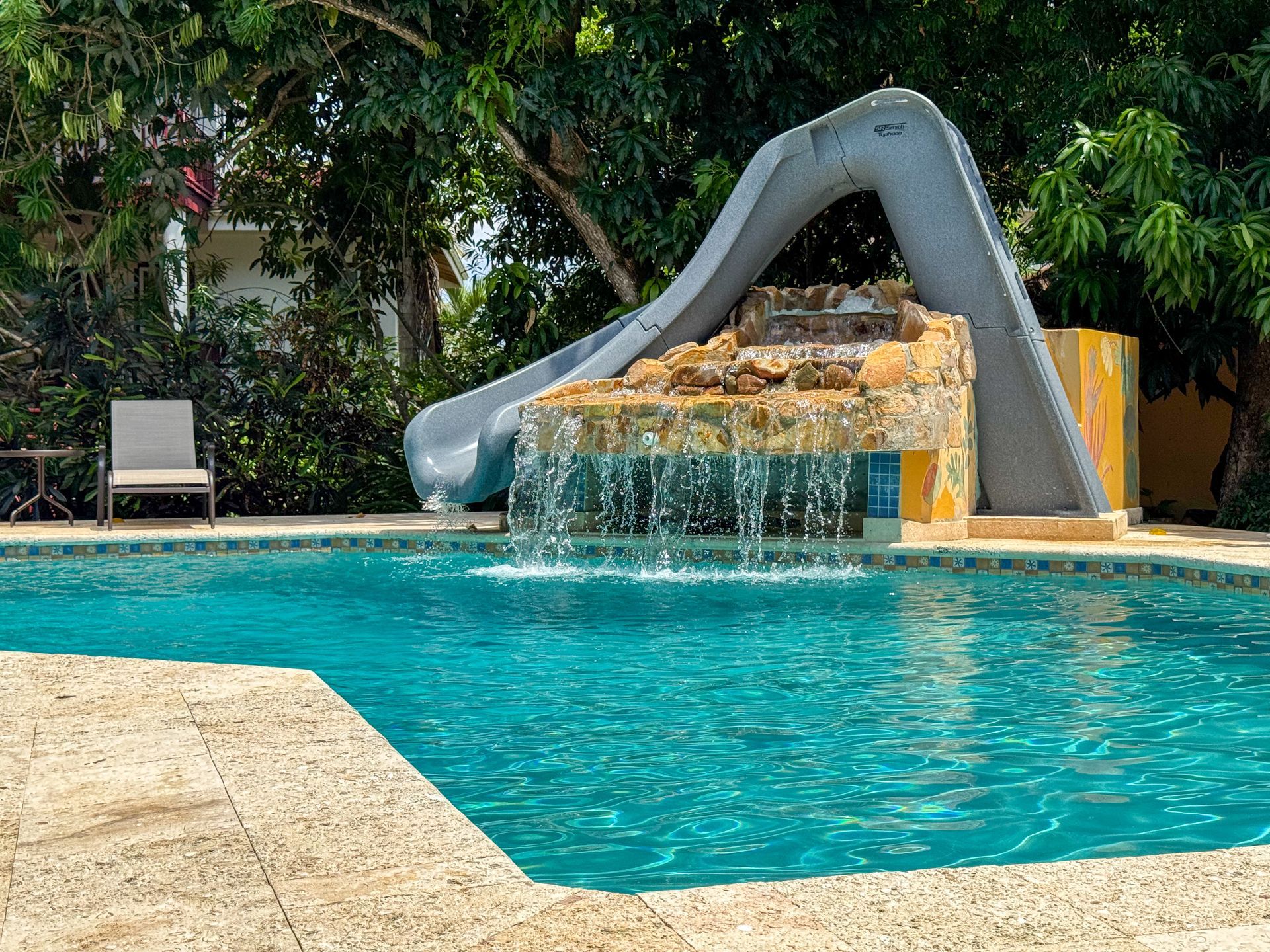 A swimming pool with a water slide and a waterfall