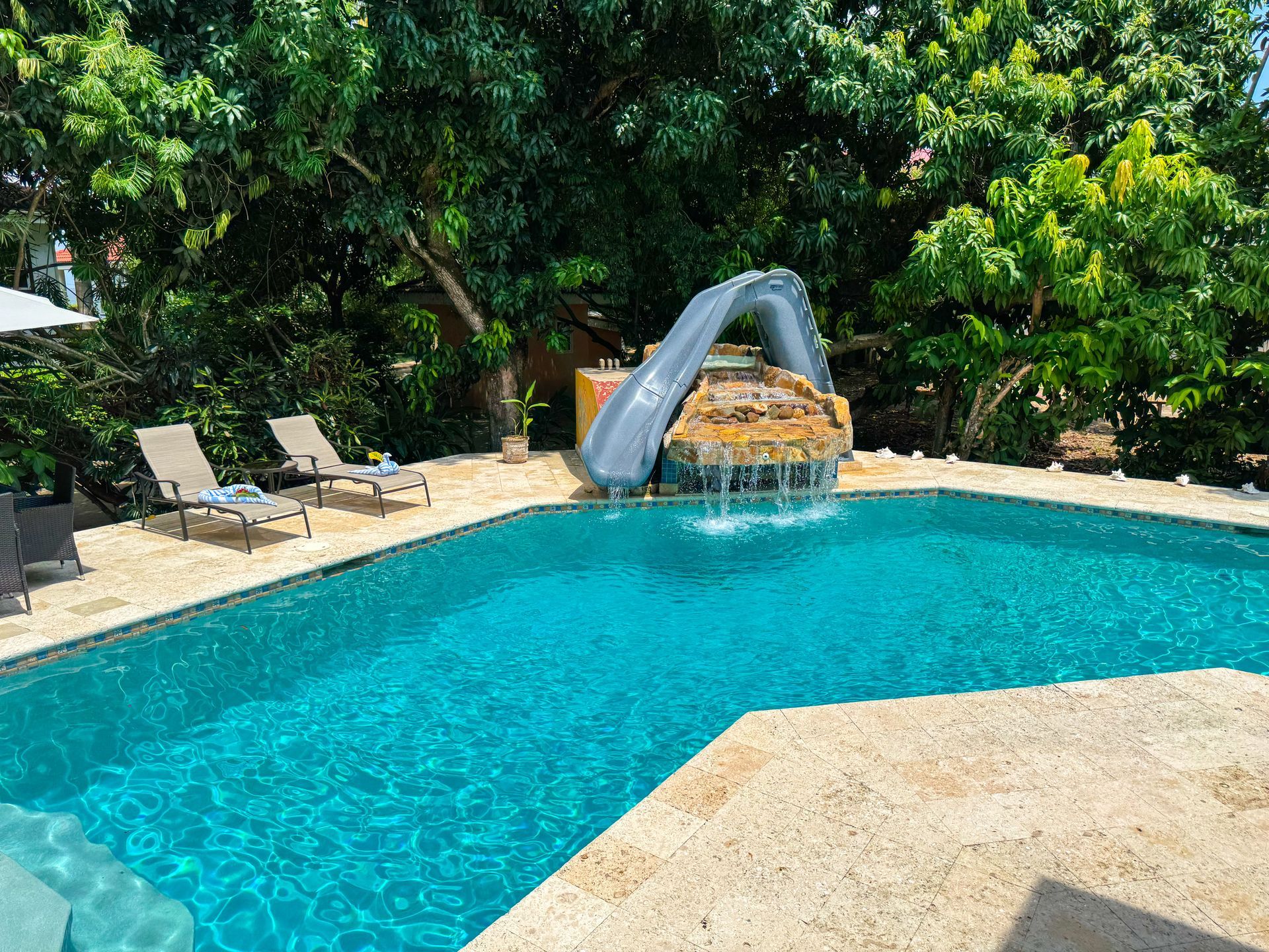 A large swimming pool with a water slide in the middle