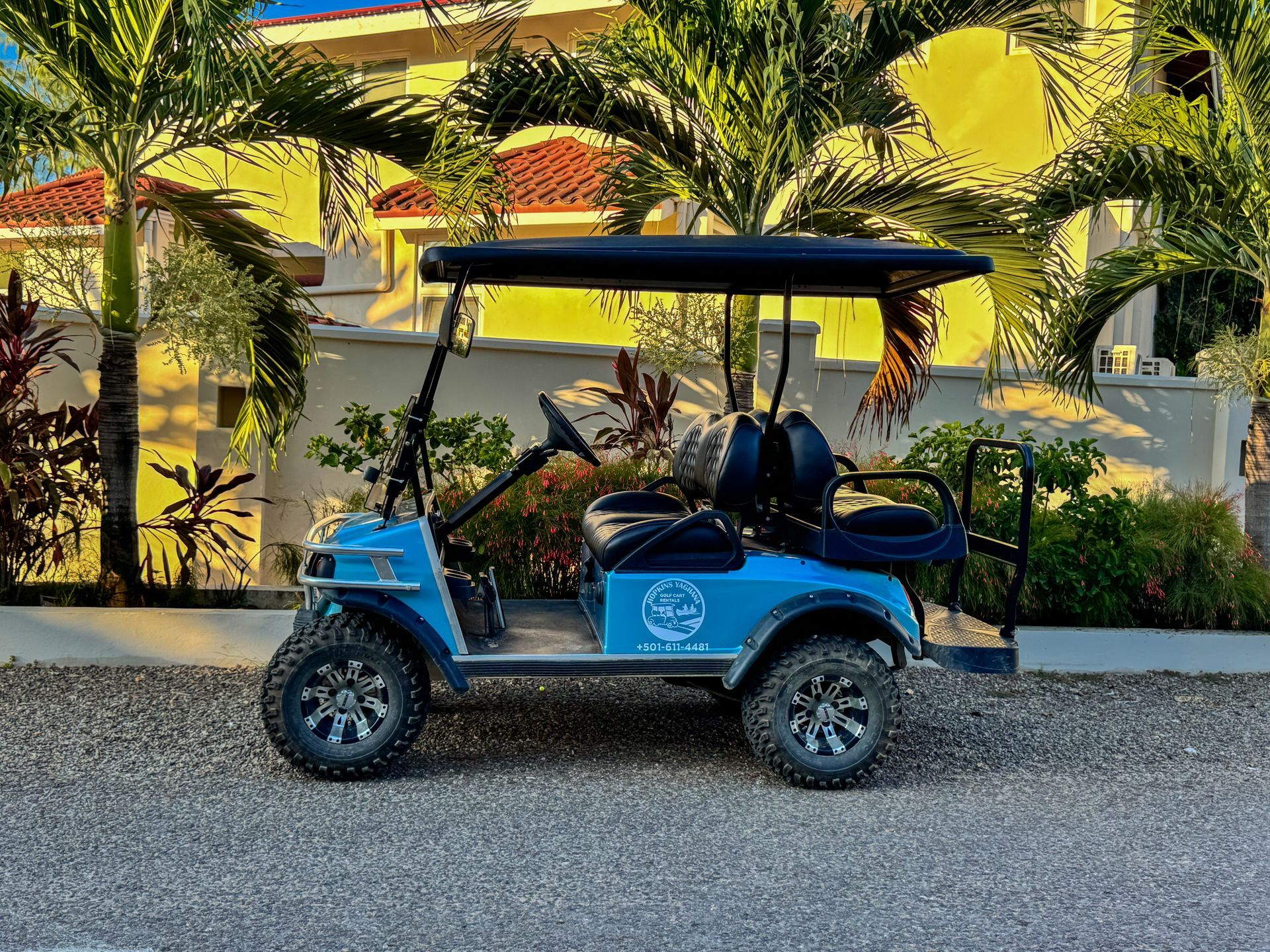 A blue golf cart is parked in front of a building.