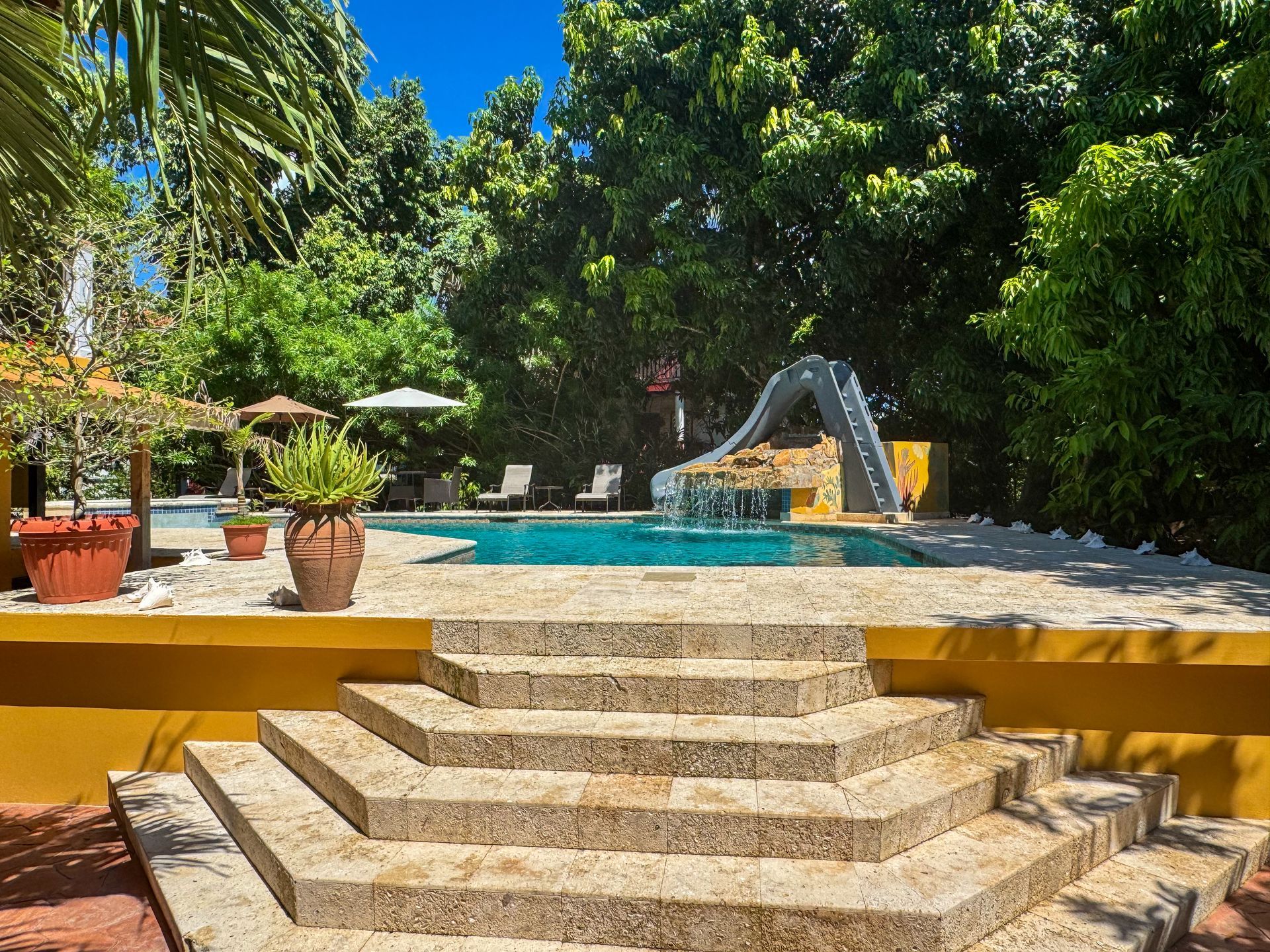 A swimming pool with stairs leading up to it and a slide.