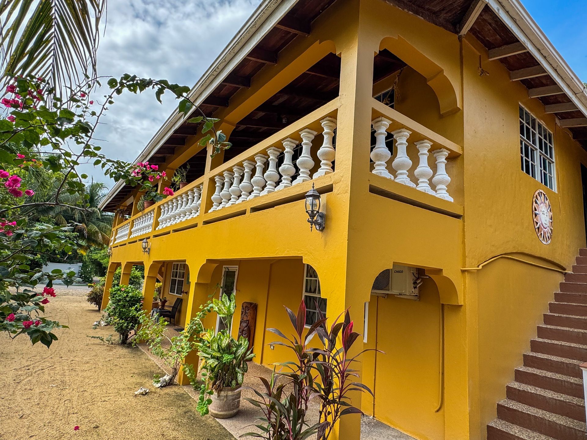 A large yellow house with a balcony and stairs