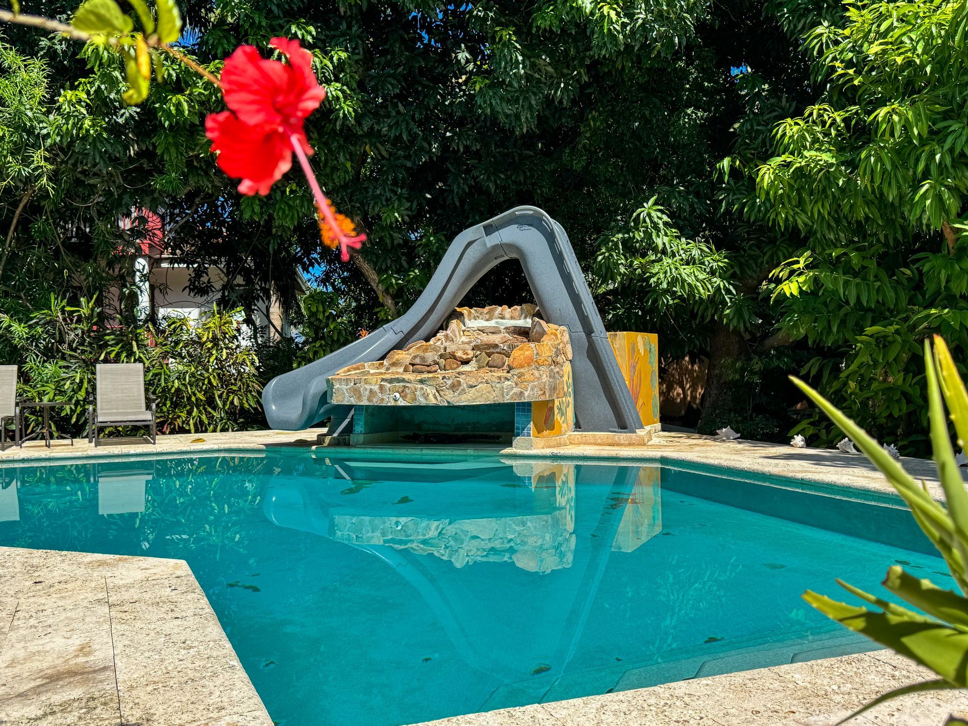 A large swimming pool with a slide in the middle of it