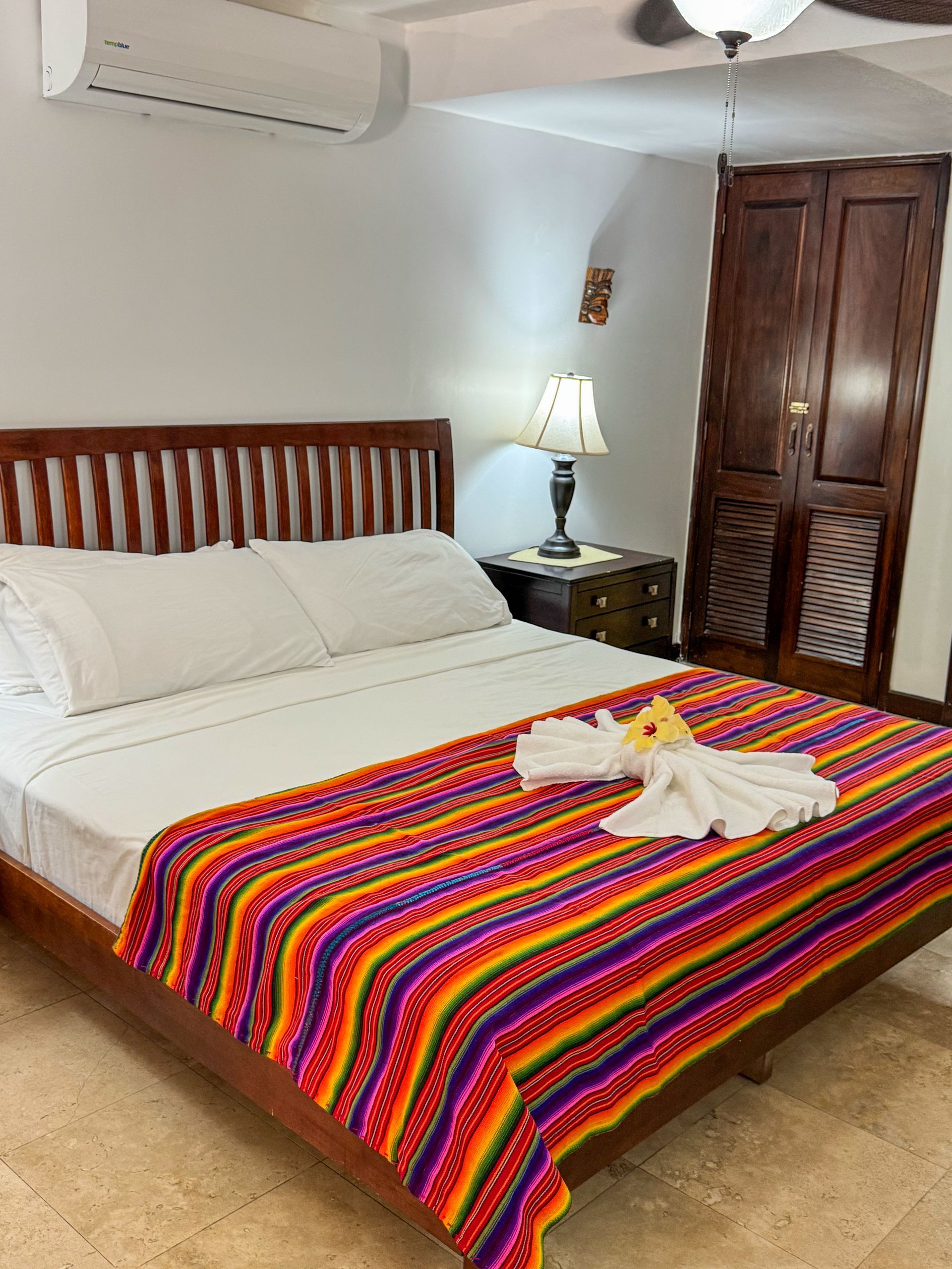 A bed with a colorful blanket on it in a hotel room