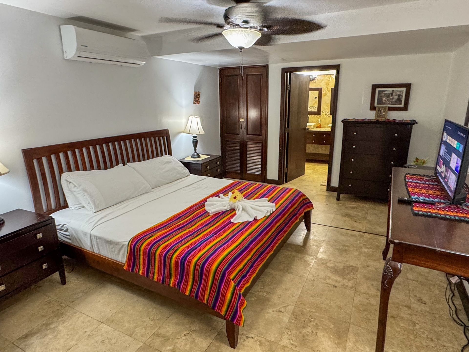 A bedroom with a king size bed and a ceiling fan, best accommodations for groups in Hopkins, Belize