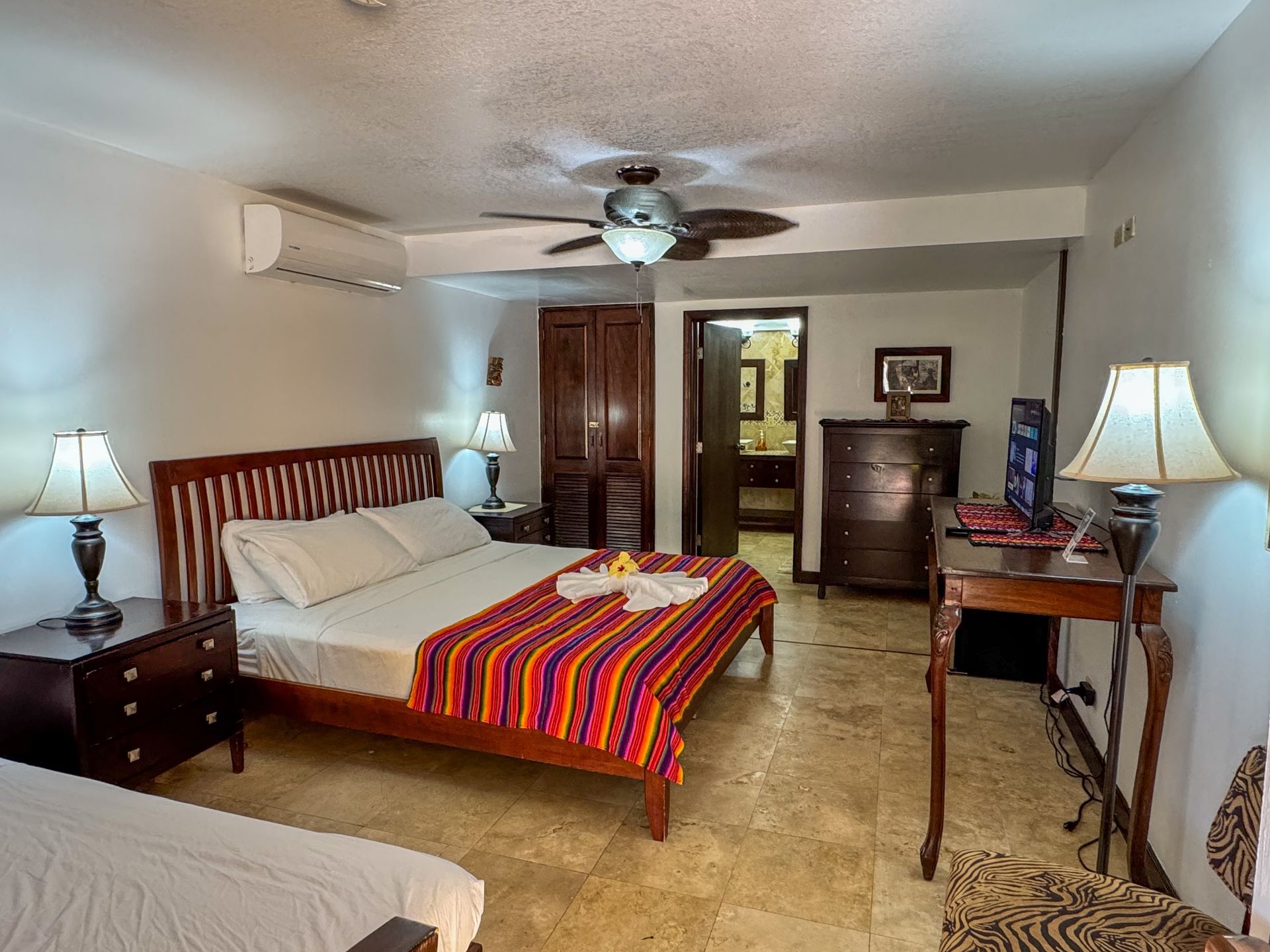 A hotel room with two beds and a ceiling fan, group friendly accommodation in Hopkins Village Belize