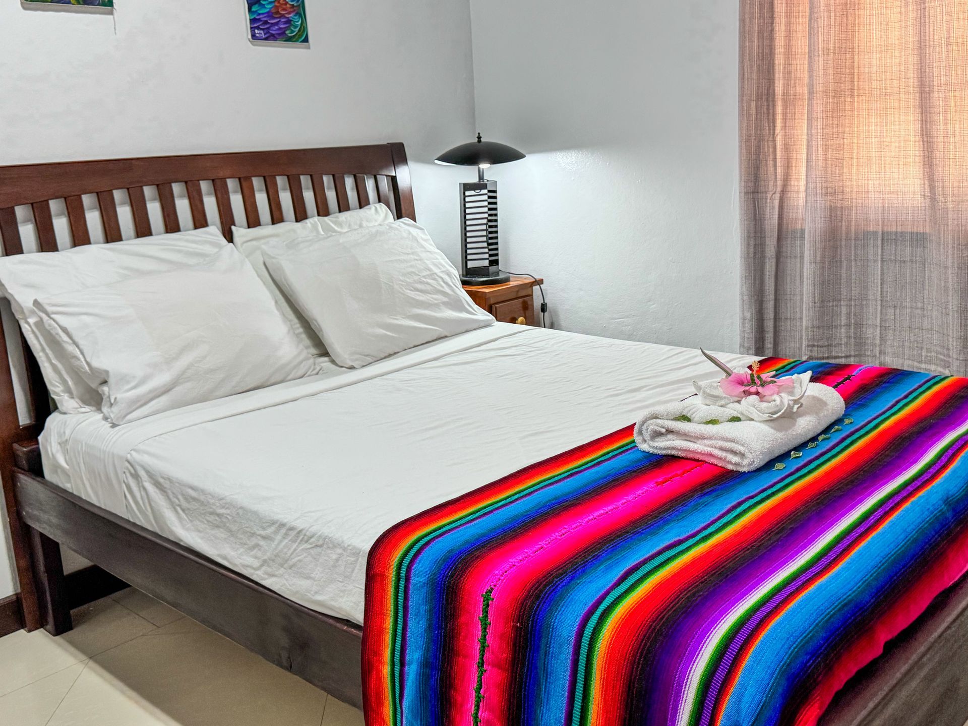 A bed with a colorful blanket on it in a bedroom.