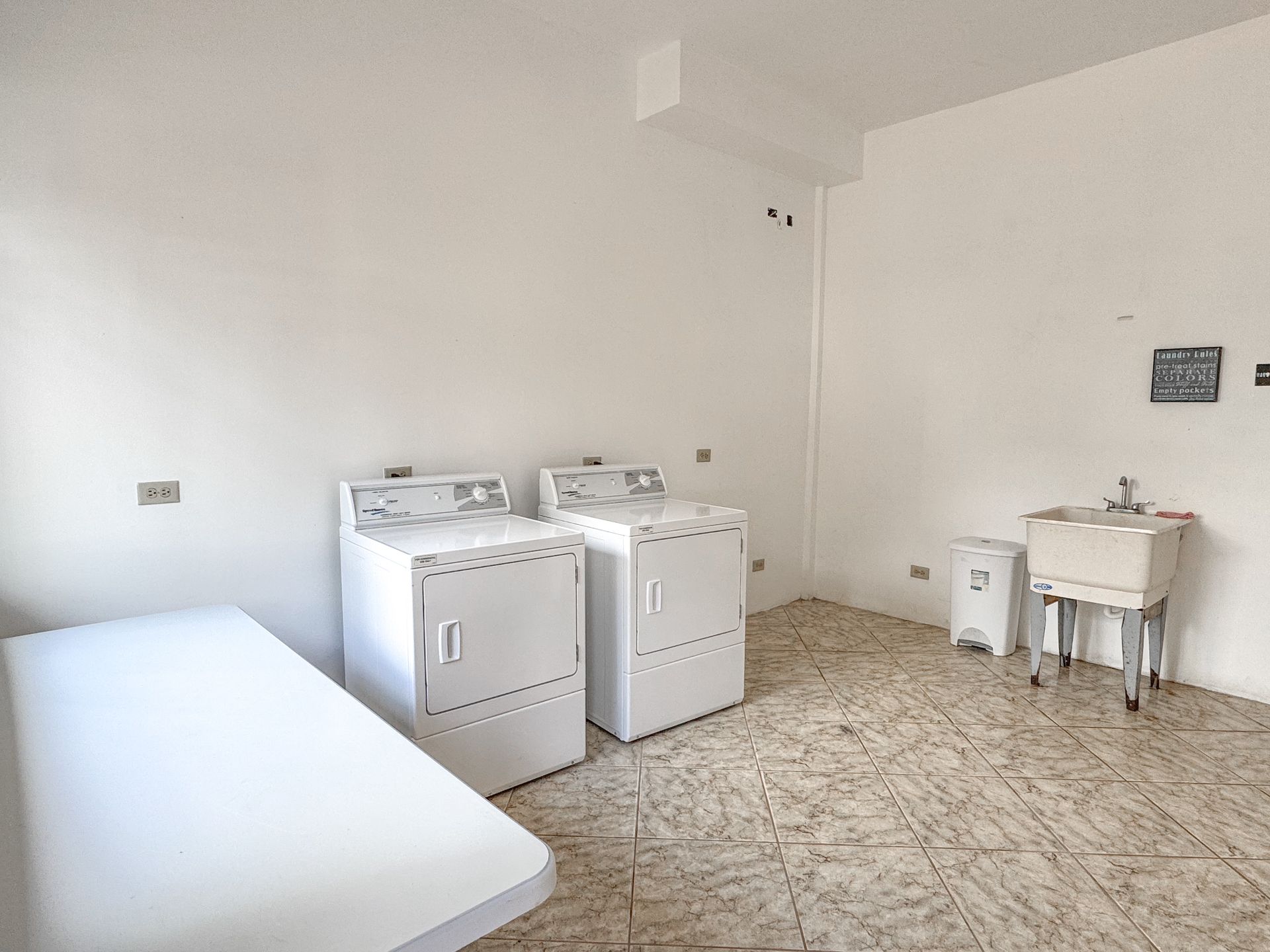 A laundry room with a washer and dryer and a sink.