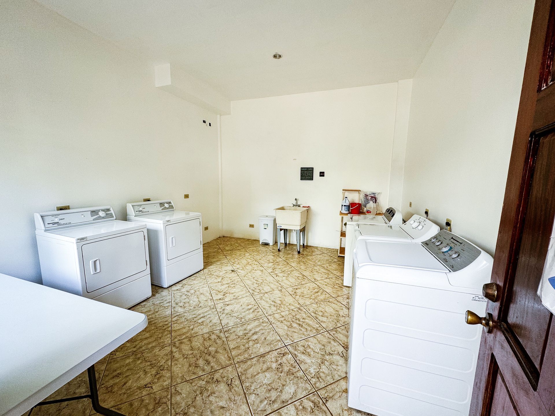 A laundry room with a washer and dryer and a table.