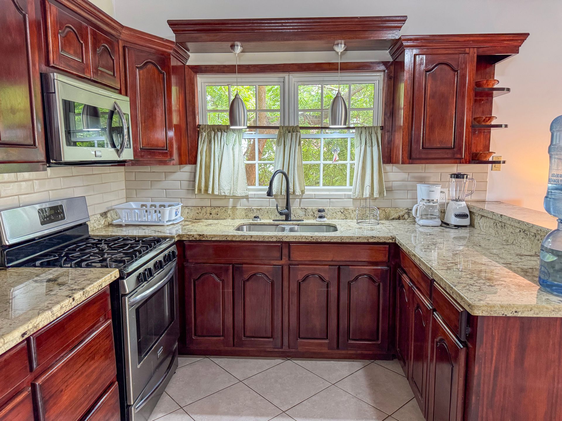 A kitchen with wooden cabinets, stainless steel appliances at the studio apartment in Hopkins Village, belize