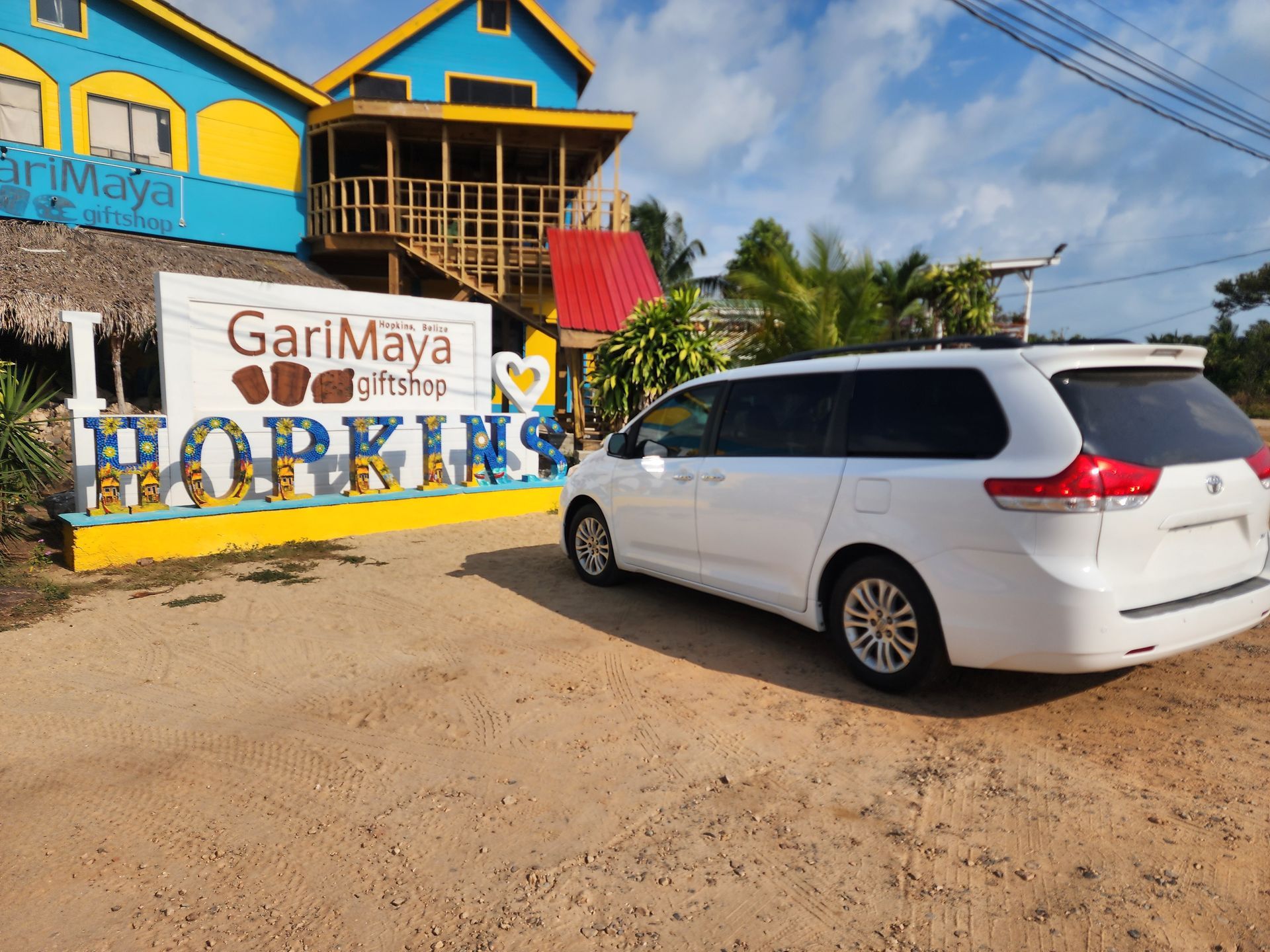 shuttle van parked infront of the Hopkins Sign, Shuttle service to Caribbean Shores B&B 