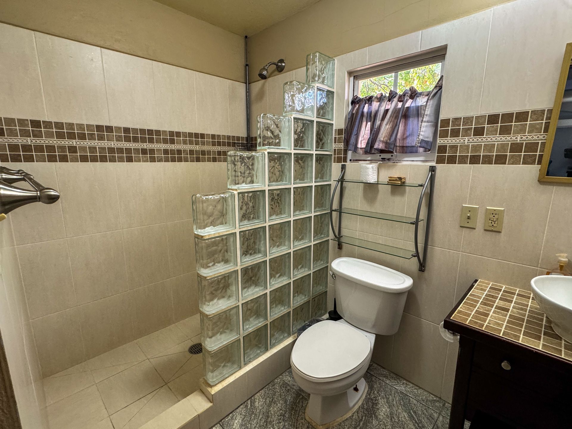 odern private bathroom at Caribbean Shores Bed & Breakfast in Hopkins Belize with walk-in shower and tropical decor.