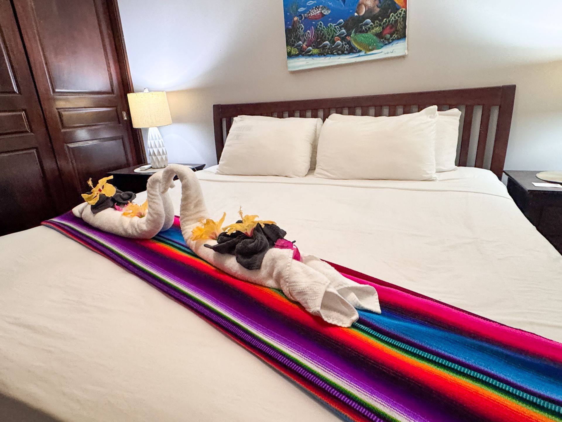 A hotel room with a bed decorated with towels and flowers.