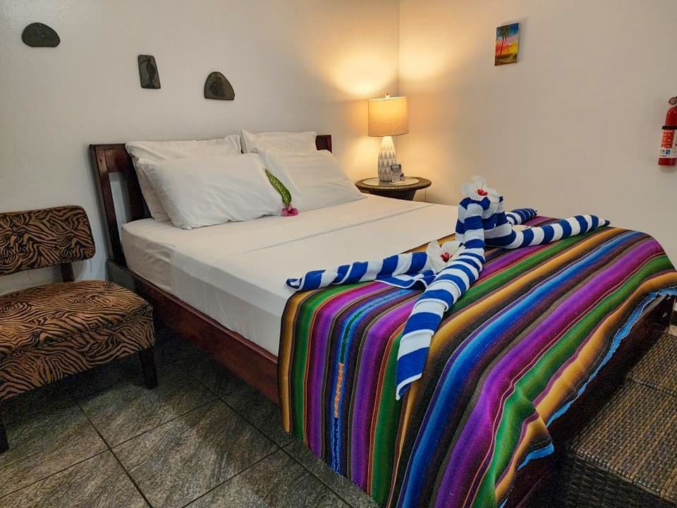 A bed with a colorful blanket on it in a hotel room, budget friendly hotel in Hopkins Village 