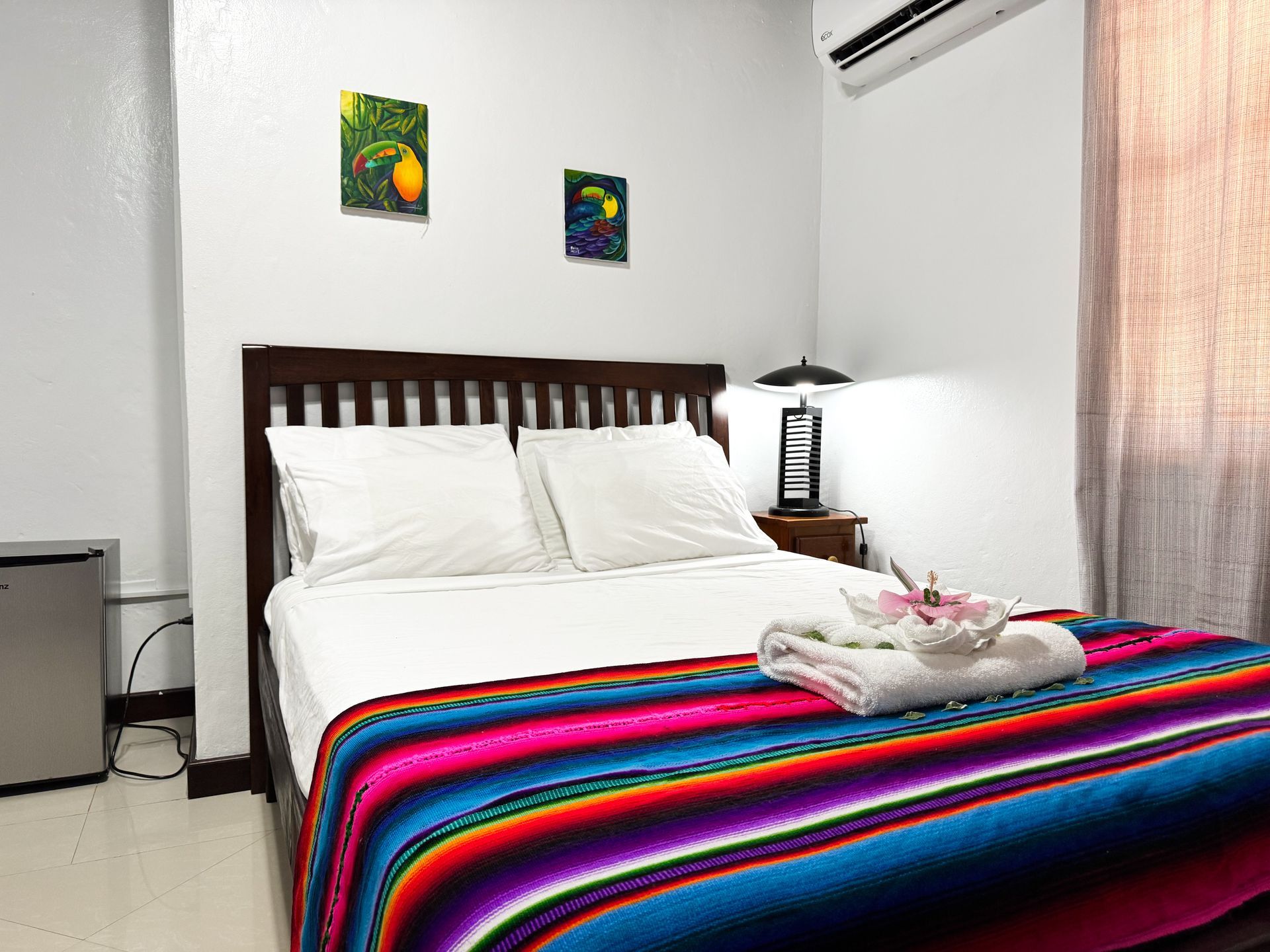 A bedroom with a bed and a colorful blanket, double room in Hopkins Village
