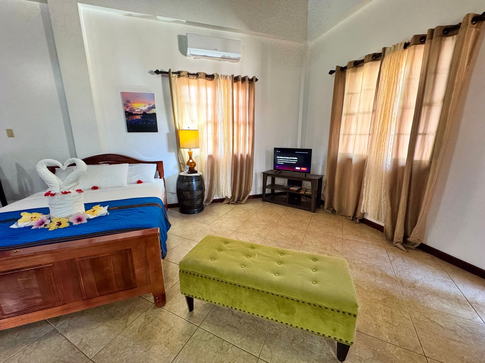 A bedroom with a bed , ottoman , and television, accommodations in Hopkins Village