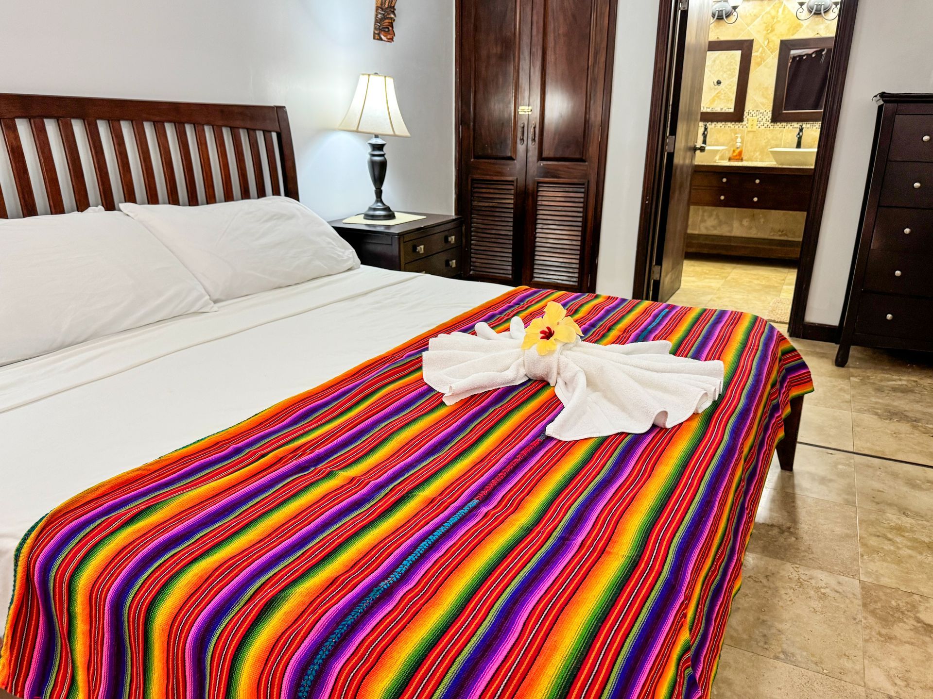 A bed with a colorful blanket and flowers on it