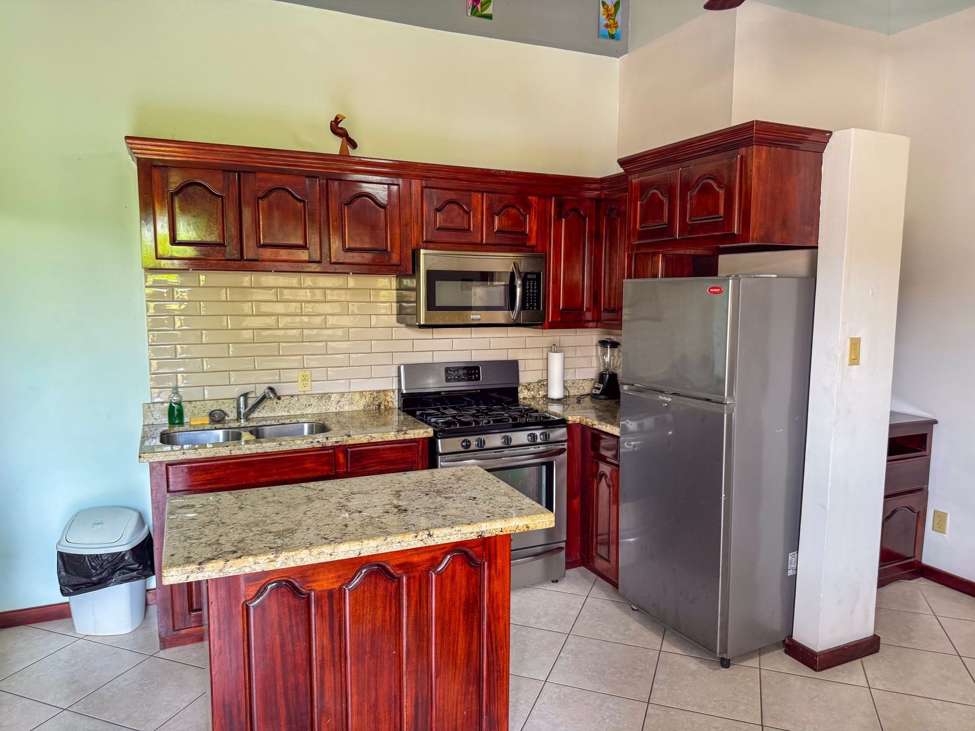 A kitchen with stainless steel appliances and wooden cabinets, family friendly hotel in Hopkisn Village