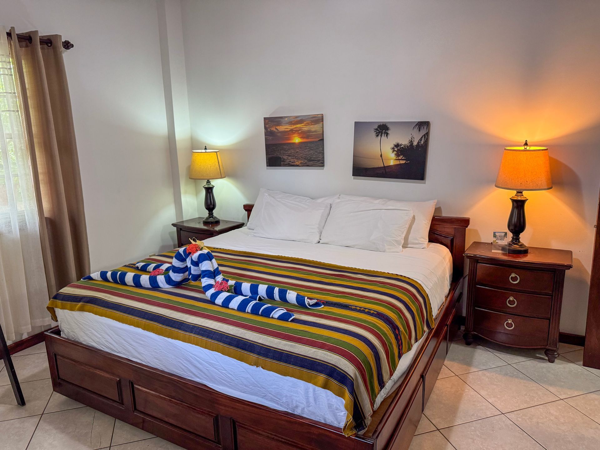 A bedroom with a king size bed , two nightstands , two lamps, Hopkins Belize hotels and lodgings