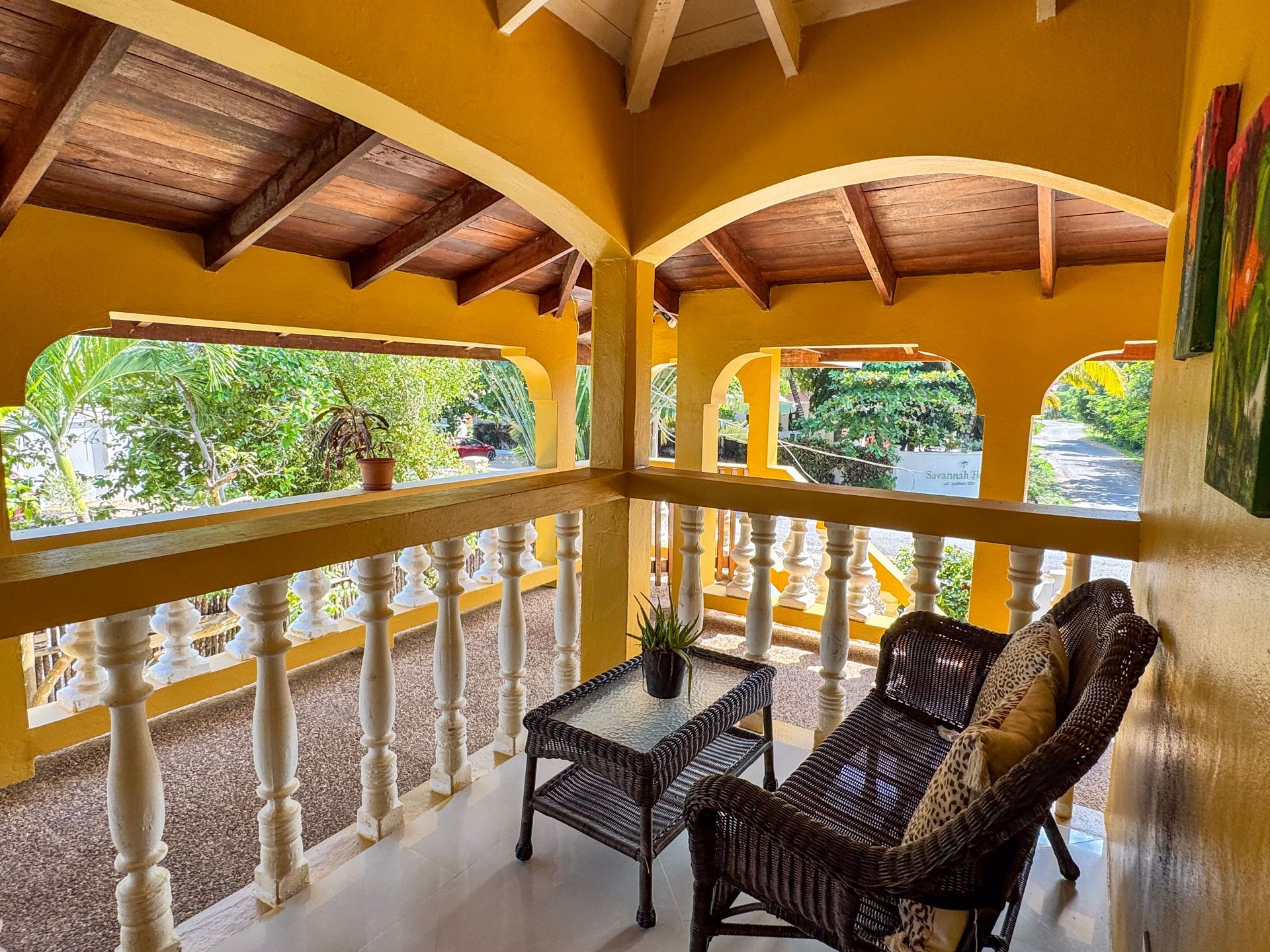 A balcony with a couch and a table on it at Caribbean Shores B&B, Hopkins Village