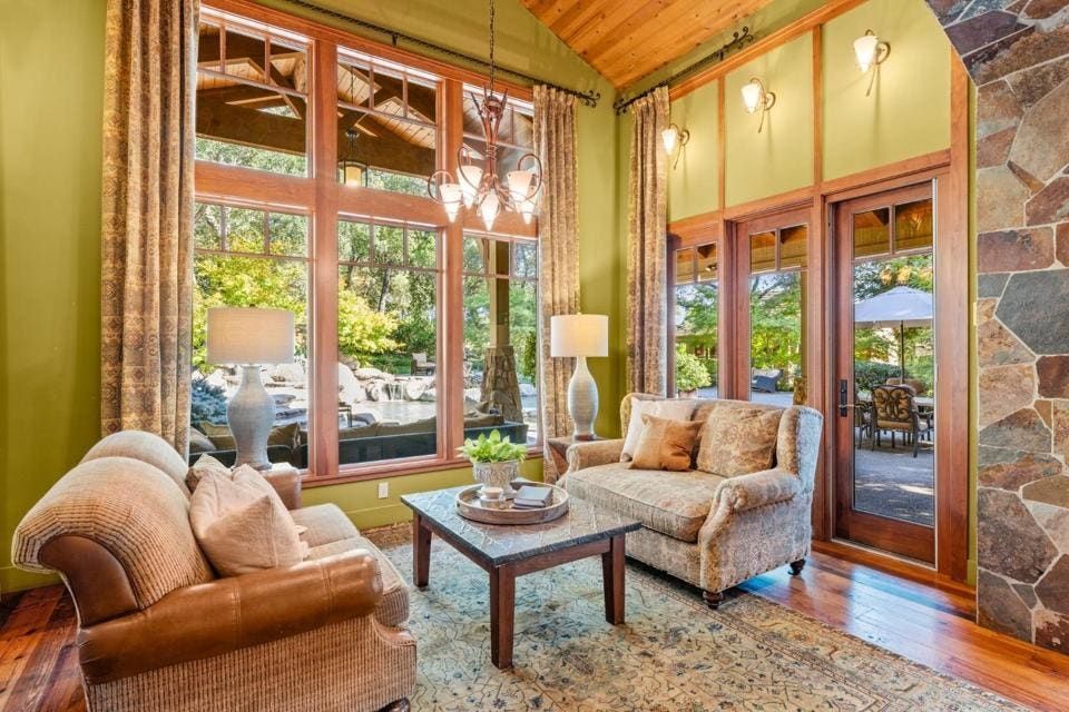 Oversized picture windows and French doors take in the leafy grounds.