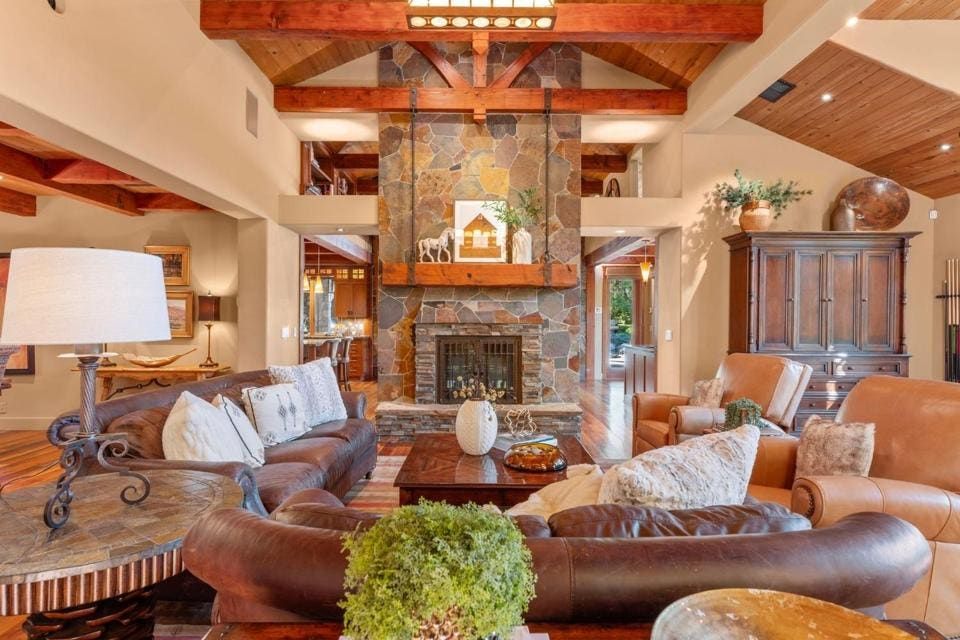 The grand living room features a stone fireplace and 10-foot hidden theater screen.