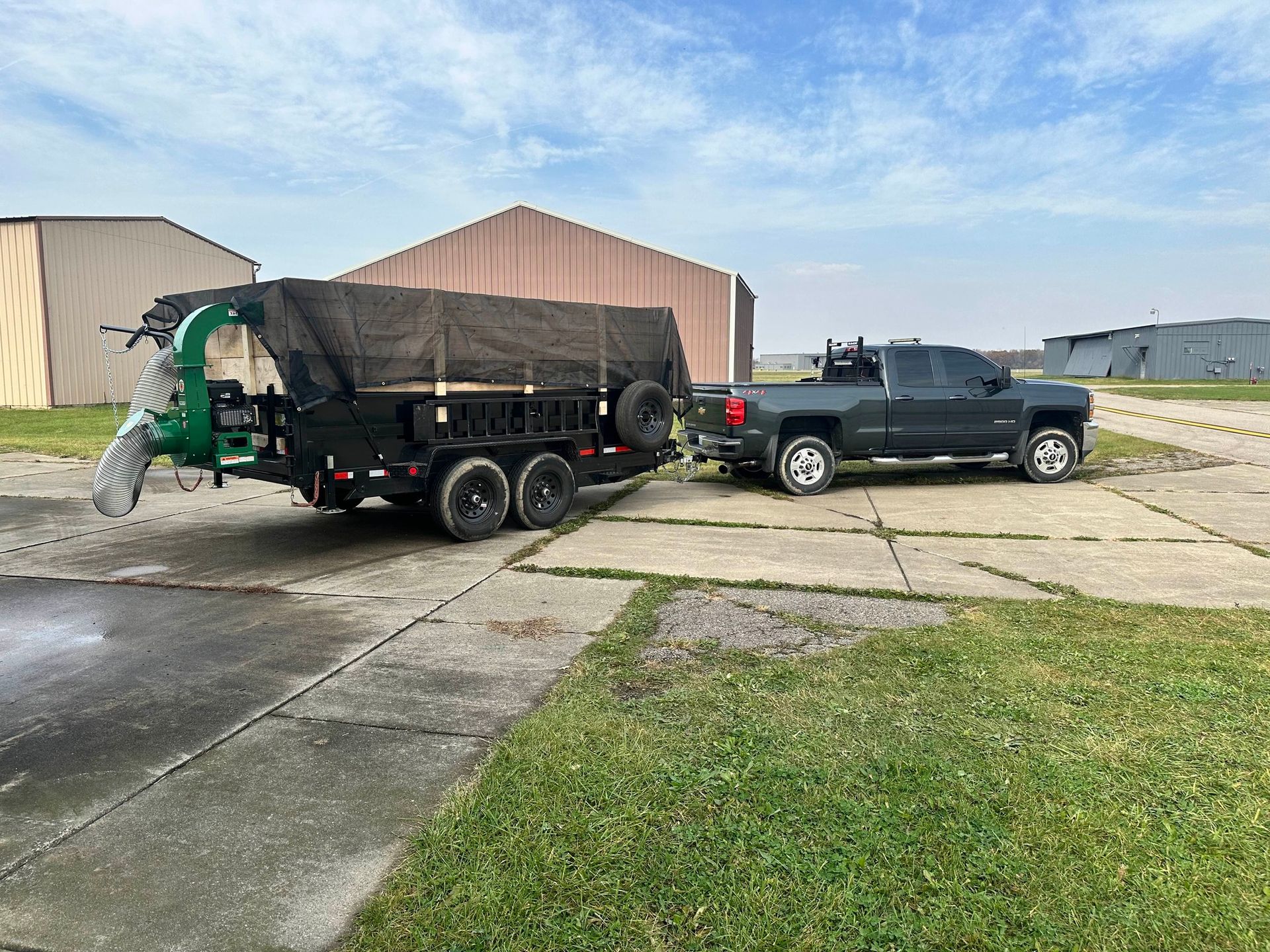 A truck is towing a trailer with a tree chipper attached to it.