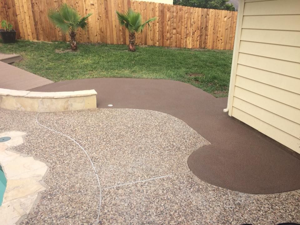 A patio with a wooden fence and palm trees in the background