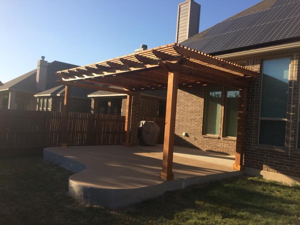 A brick house with a wooden pergola in the backyard