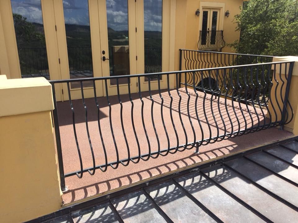 A balcony with a wrought iron railing on the side of a building.