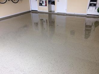 A garage with a shiny floor and a bicycle hanging on the wall.
