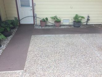 A patio with potted plants in front of a house