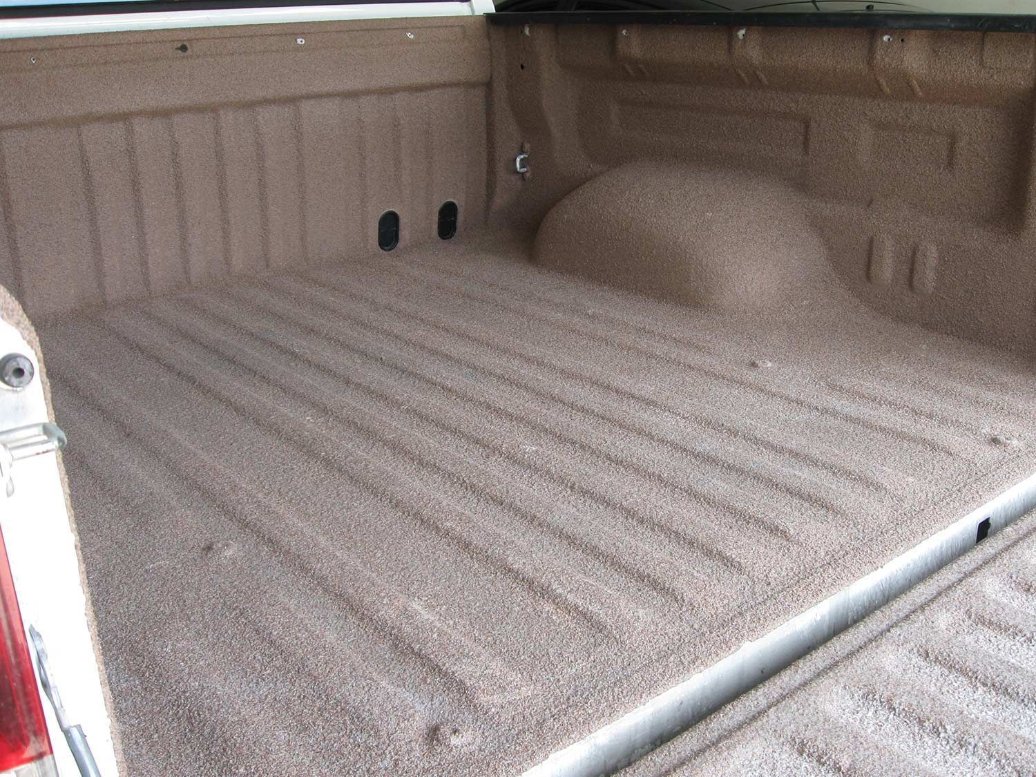 The back of a truck with a carpeted bed