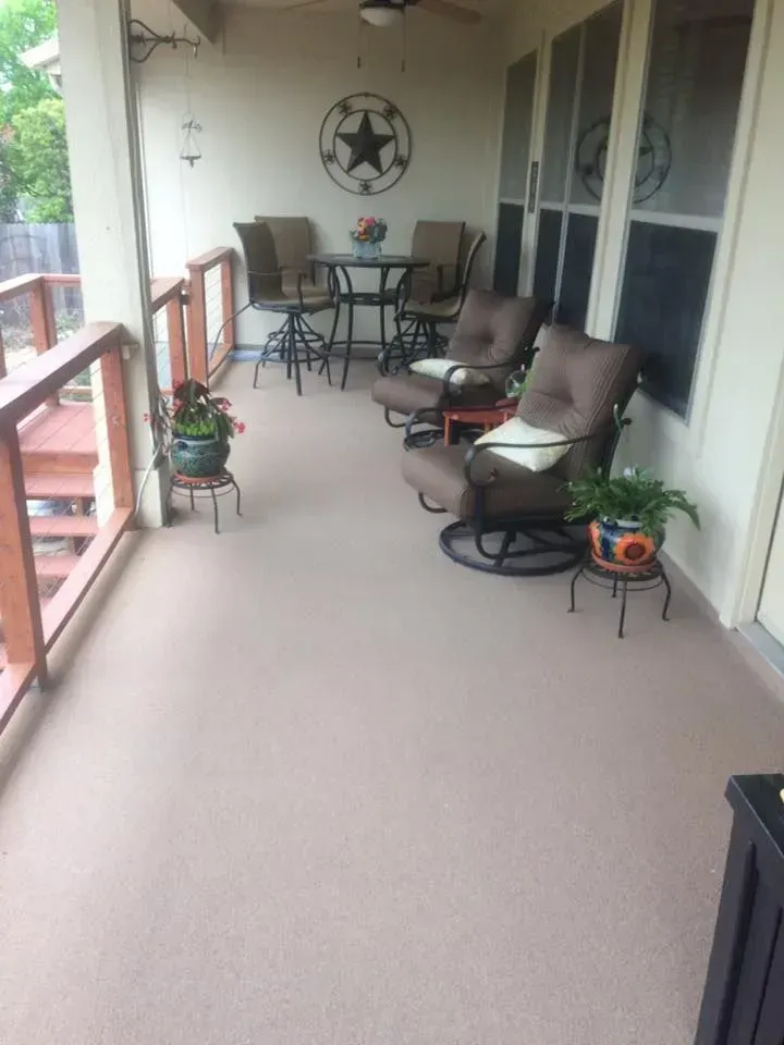 A porch with a table and chairs on it