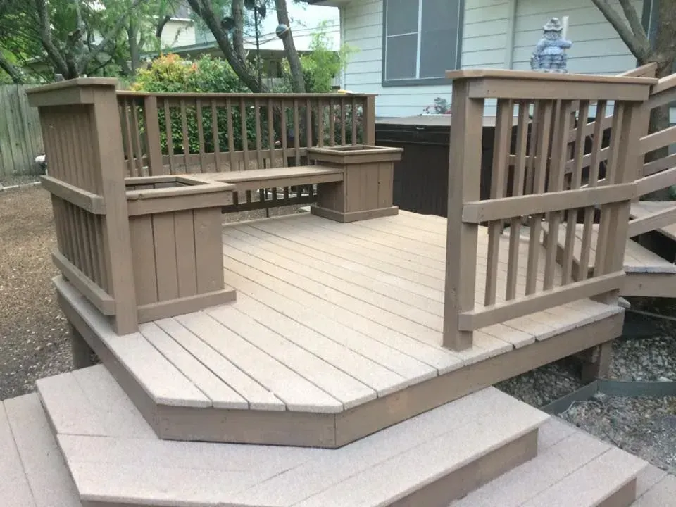 A wooden deck with stairs and a bench