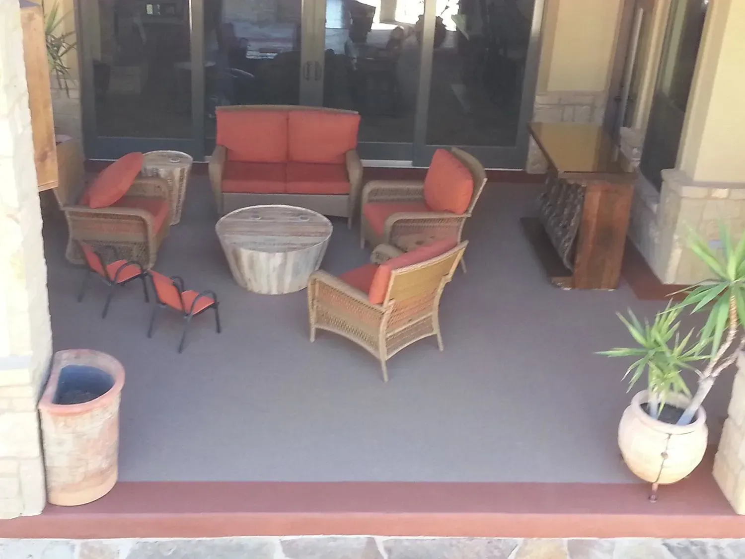 A patio with wicker furniture and a potted plant