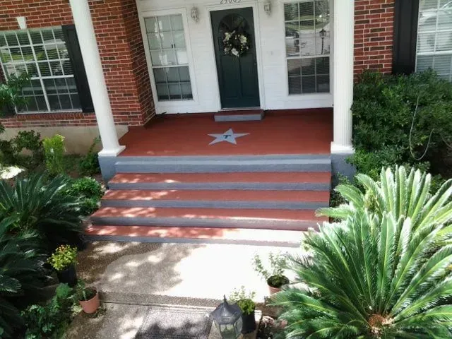 The front porch of a brick house has a star painted on it