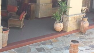 A patio with potted plants in front of a house