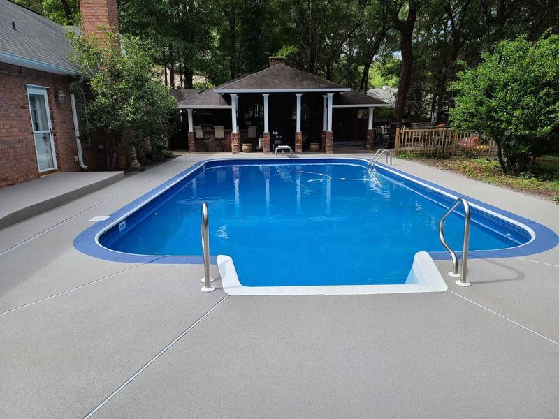 A large swimming pool with a gazebo in the background