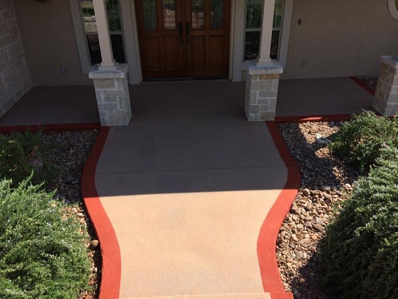 A concrete walkway leading to the front door of a house
