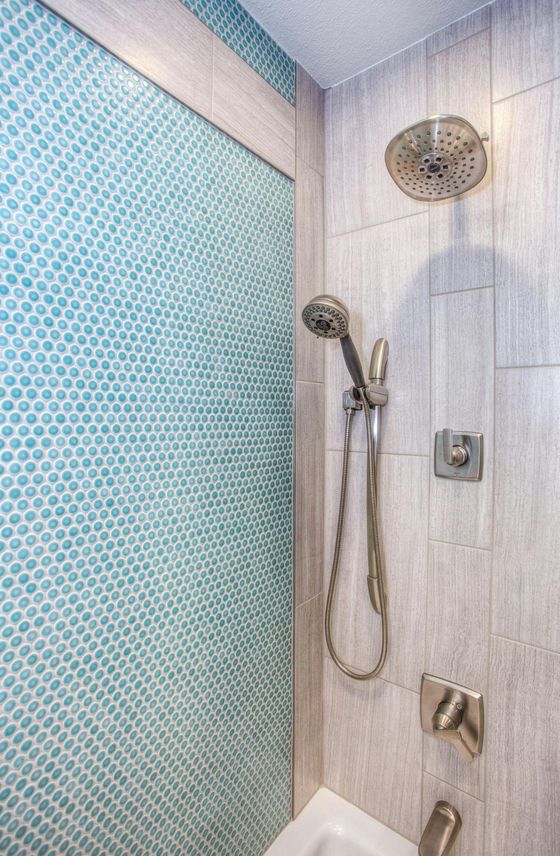 A bathroom with a shower head and a tub.