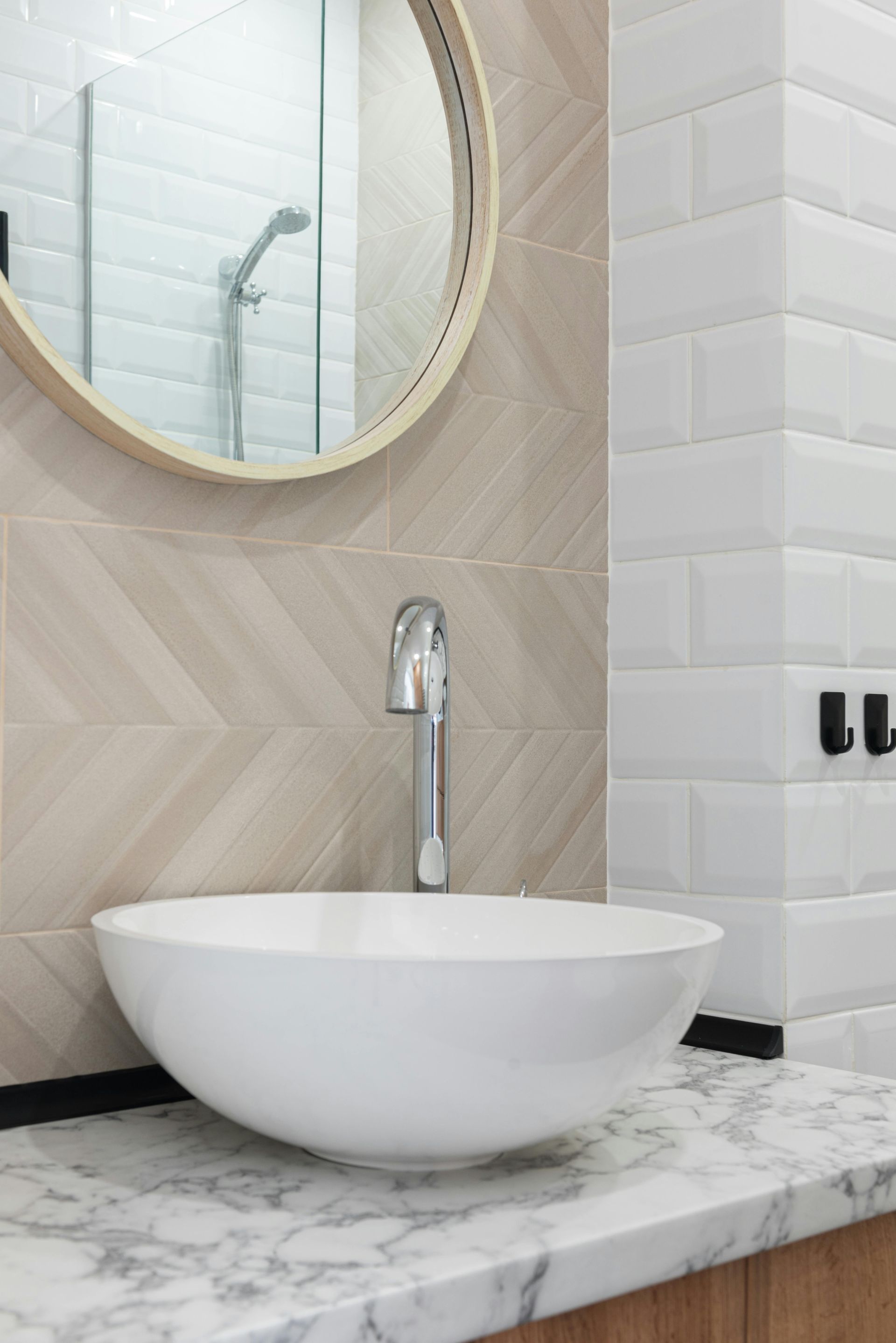 A bathroom with a round mirror and a sink.