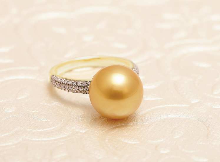 Gold ring with a large golden pearl and small diamonds.