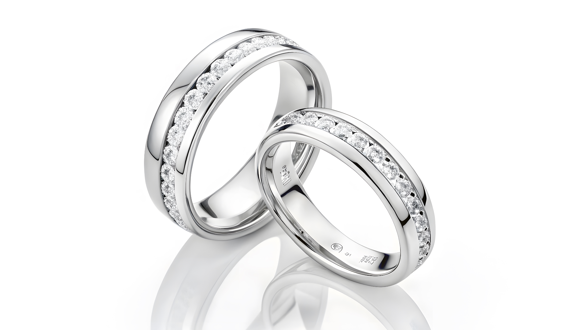 Two silver wedding rings with channel-set diamonds, on a white background.