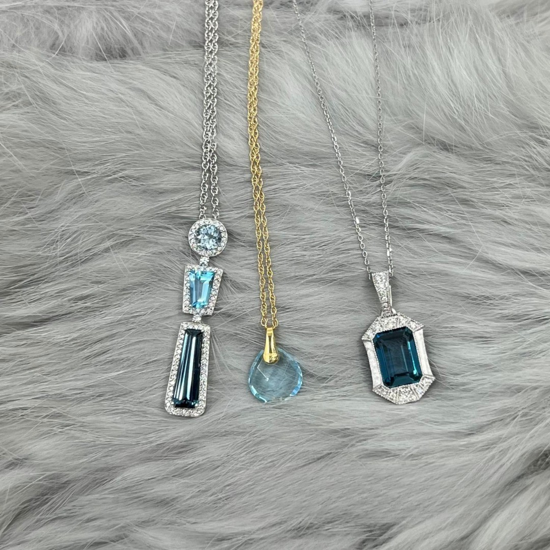 Three gemstone necklaces on a gray furry surface
