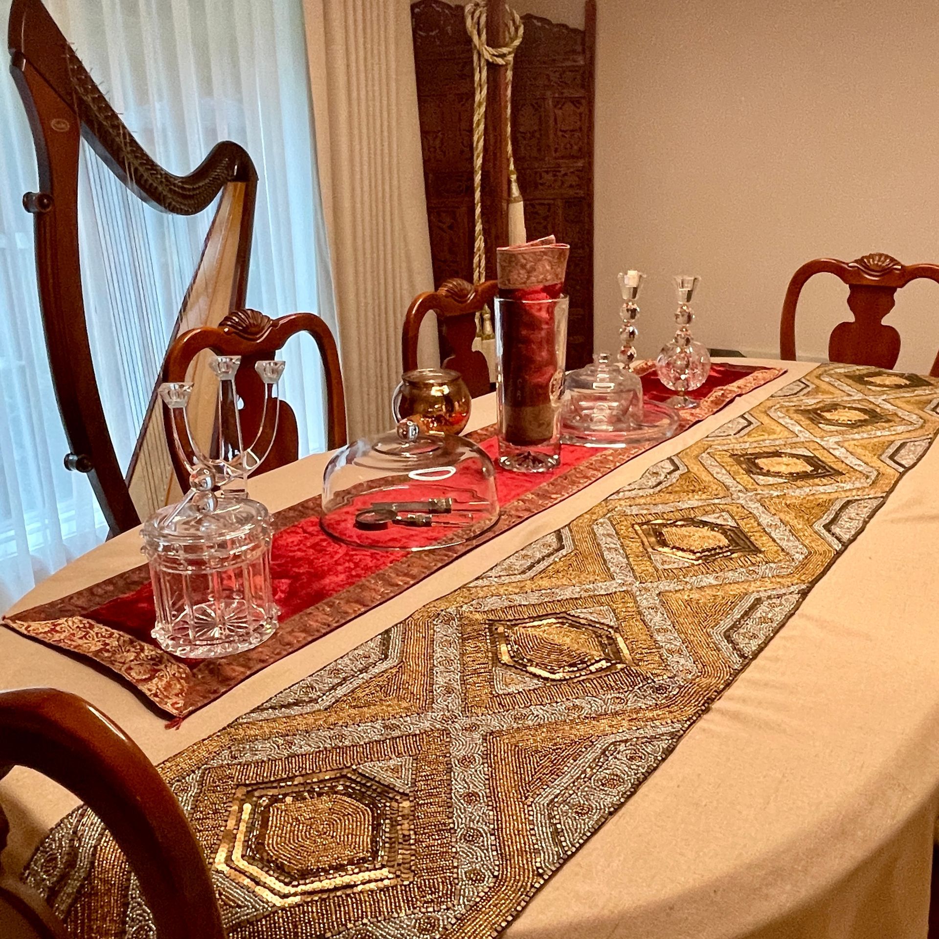 Dining room with a table set with crystal, harp visible.
