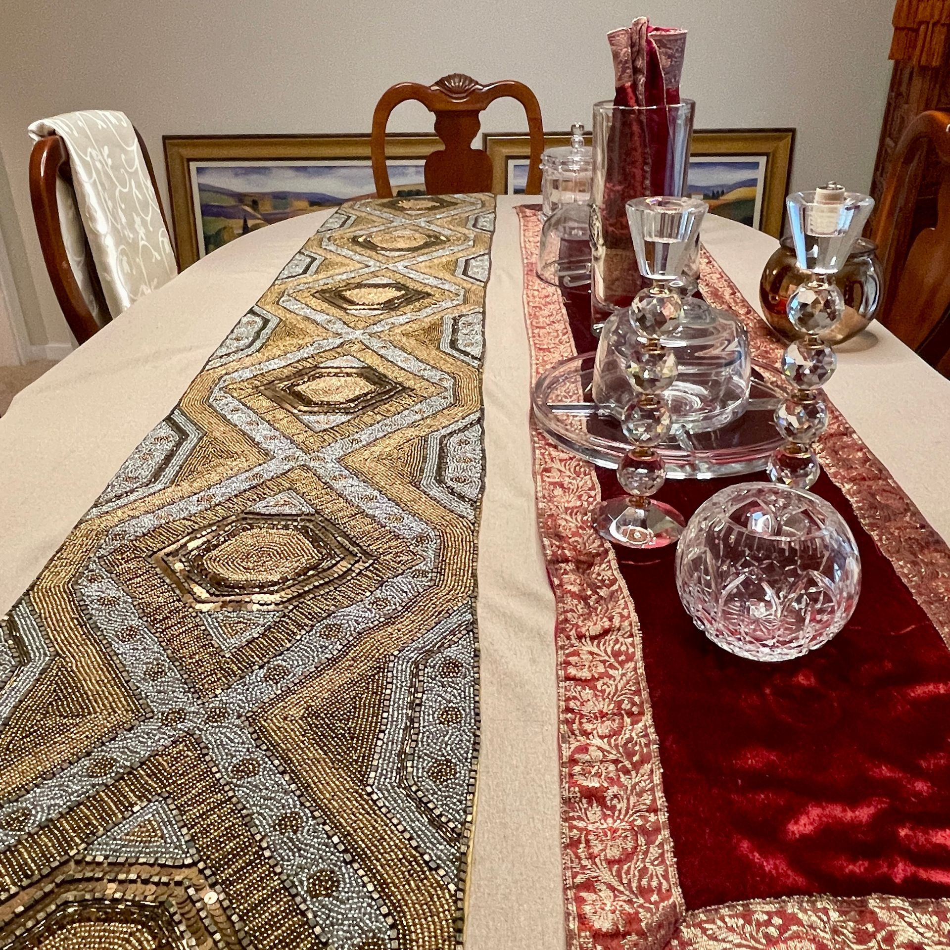 Dining table with two decorative runners: gold and maroon, with crystal decor.